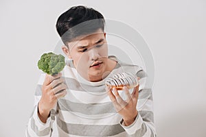 Man having hard choice between healthy and unhealthy food