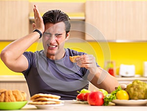 Man having hard choice between healthy and unhealthy food