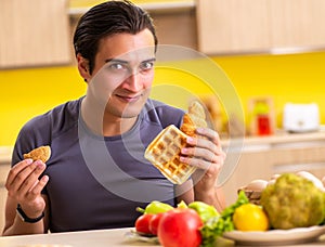 Man having hard choice between healthy and unhealthy food