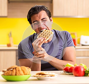 Man having hard choice between healthy and unhealthy food