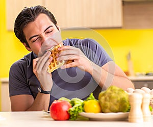 Man having hard choice between healthy and unhealthy food