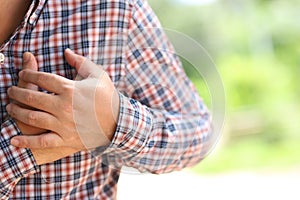 Man having heart ache, holding hand on her chest. Heart attack or stroke. Health care concept.