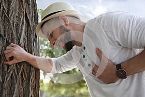 Man having heart attack near tree in park