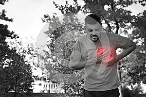 Man having heart attack in park. Black and white photo