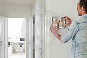man having Home automation control station in a modern home 3D render