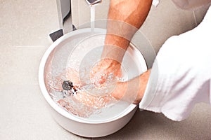 Man having hydrotherapy water footbath photo