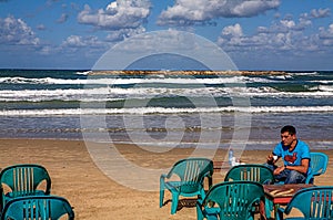 Man having Morning coffee on the beach in Tel Aviv, Israel