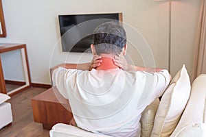 Man having Neck and Shoulder pain during sitting on sofa. due to fibromyalgia, rheumatism, Scapular pain, office syndrome and