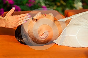 Man having oil Ayurveda spa treatment.handsome bearded dark haired male model relaxing on beach.spa and relaxation
