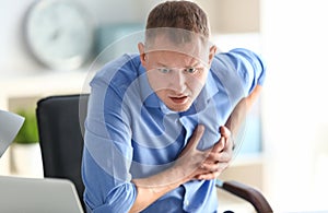 Man having panic attack at workplace in office