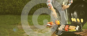 Man having picnic and cooking food on barbecue grill outdoors, closeup. Banner design