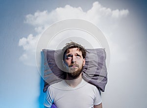 Man having problems/ insomnia, laying in bed on pillow photo