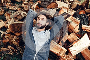 Man having rest on pile of wood top view