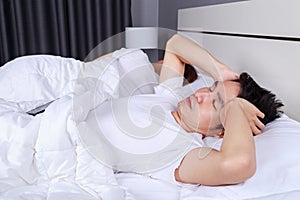 Man having sleepless on bed and having migraine,stress, insomnia
