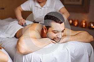 Man having stone massage in spa salon. Healthy lifestyle concept