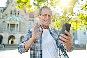 Man having video call talking via smartphone and internet while visiting new city.