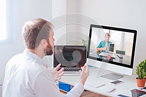 Man having virtual meeting with his coworker at home