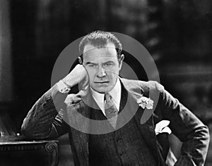 Man with head leaning against his hand thinking