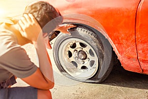 A man headache when car breakdown and wheel flat tire in parking