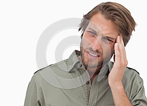 Man with headache looking away and wincing