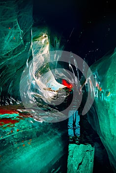 Man with headlamp in amazing blue ice cave