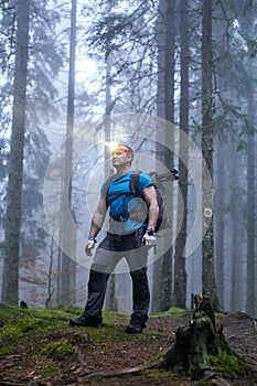 Man with headlamp and backpack in the forest photo