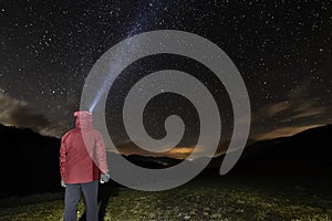 Man with headlamp looking at the starry night sky