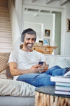 Man, headphones and laughing for phone on couch with funny social media post and comedy movie on mobile app. Person