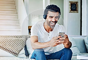 Man, headphones and laughing for phone on sofa with funny social media post and comedy movie on mobile app. Person