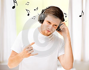 Man with headphones listening rock music at home