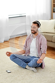 Man in headphones meditating listening to music