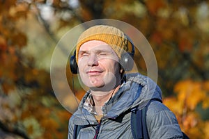 Man with headphones outdoors in a sunny autumn day