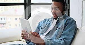 Man in headphones playing game on digital tablet