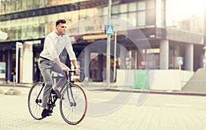 Man with headphones riding bicycle on city street