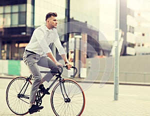 Man with headphones riding bicycle on city street