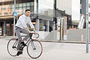 Man with headphones riding bicycle on city street