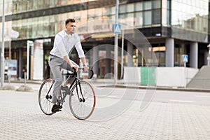 Man with headphones riding bicycle on city street