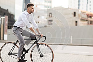 Man with headphones riding bicycle on city street