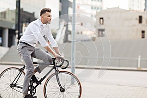 Man with headphones riding bicycle on city street