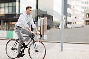 Man with headphones riding bicycle on city street