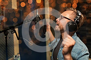 Man with headphones singing at recording studio