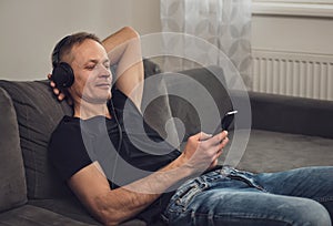 The man in headphones and with a smartphone.