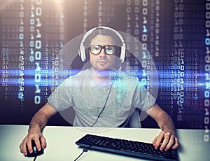 Man in headset hacking computer or programming