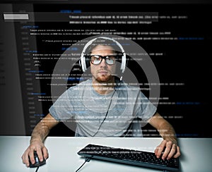 Man in headset hacking computer or programming