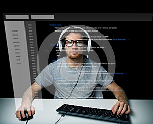 Man in headset hacking computer or programming