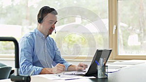 Man with headset and laptop working at home