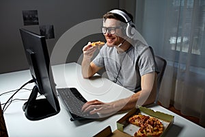 Man in headset playing computer video game at home