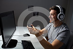 Man in headset playing computer video game at home