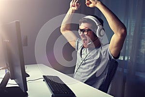 Man in headset playing computer video game at home