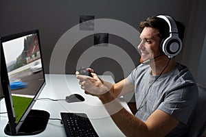 Man in headset playing computer video game at home